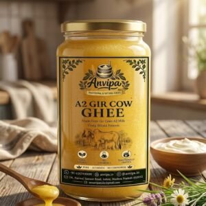 A premium glass jar of Anvipa chemical-free Pure A2 Gir Cow Ghee showing its rich granular golden texture on a rustic wooden table.