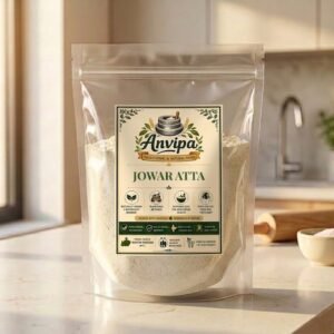 A premium pack of Anvipa chemical-free Jowar Atta with raw sorghum grains scattered on a rustic background, highlighting traditional stone milled gluten-free millet flour.