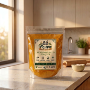 A premium pouch of Anvipa chemical-free Pure Lakadong Turmeric Powder beside a small terracotta bowl filled with cold ground bright golden-amber haldi.