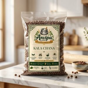 A premium pouch of Anvipa chemical-free Pure Desi Kala Chana beside a small wooden scoop showing raw, unpolished, and textured brown-black chickpeas.