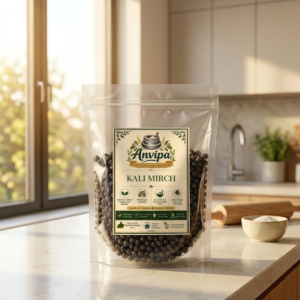 A premium pouch of Anvipa chemical-free Pure Black Pepper Kali Mirch beside a small terracotta bowl filled with raw, plump whole black peppercorns.